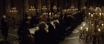 Movie still from “The Duchess” (2008), directed by Saul Dibb – A group of people sitting around a table with candles; Wide shot, High angle