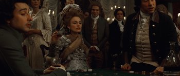 Movie still from “The Duchess” (2008), directed by Saul Dibb – A woman in a silver dress is sitting in front of a table; Medium shot, Over the shoulder angle