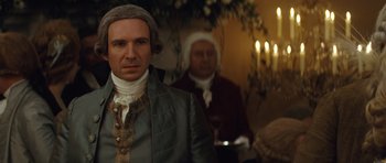 Movie still from “The Duchess” (2008), directed by Saul Dibb – A man dressed in period clothing standing in front of candles; Close Up shot, Over the shoulder angle