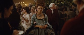 Movie still from “The Duchess” (2008), directed by Saul Dibb – A woman dressed in period clothing with a bunch of people in the background; Medium shot, Over the shoulder angle