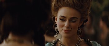 Movie still from “The Duchess” (2008), directed by Saul Dibb – A person wearing a necklace and earrings; Close Up shot, Over the shoulder angle