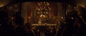 Movie still from “The Duchess” (2008), directed by Saul Dibb – A couple of people on a stage in front of a chandelier; Extreme Wide shot, High angle