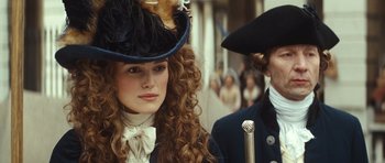 Movie still from “The Duchess” (2008), directed by Saul Dibb – A woman in a hat and a man in a hat; Close Up shot, Over the shoulder angle