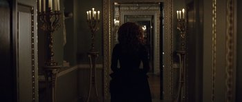 Movie still from “The Duchess” (2008), directed by Saul Dibb – A woman standing in front of a mirror in a dark room; Wide shot, Over the shoulder angle