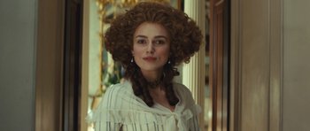 Movie still from “The Duchess” (2008), directed by Saul Dibb – A woman in a white shirt with long curly hair; Close Up shot, Over the shoulder angle