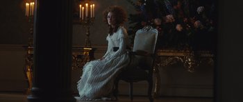 Movie still from “The Duchess” (2008), directed by Saul Dibb – A woman in a white dress sitting in a chair; Medium shot, Over the shoulder angle