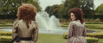 Movie still from “The Duchess” (2008), directed by Saul Dibb – Two women sitting in front of a fountain in a park; Medium shot, Over the shoulder angle
