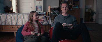 A man and a little girl are playing a video game