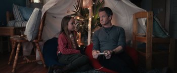 A man and a little girl are playing a video game