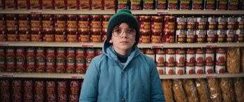A boy wearing glasses and a blue jacket