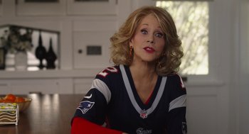 Movie still from “80 for Brady” (2023), directed by Kyle Marvin – A woman with blonde hair wearing a football jersey; Medium shot, Over the shoulder angle