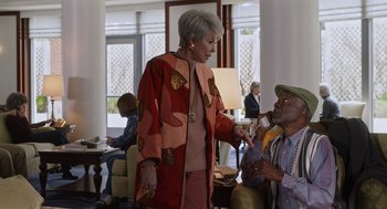 Movie still from “80 for Brady” (2023), directed by Kyle Marvin – A woman is talking to an older gentleman; Medium shot, Over the shoulder angle
