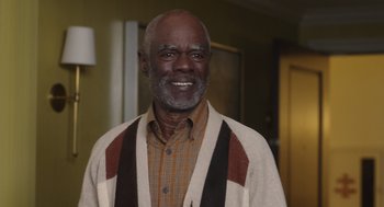 Movie still from “80 for Brady” (2023), directed by Kyle Marvin – An older man wearing a brown and white sweater; Medium shot, High angle