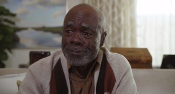 Movie still from “80 for Brady” (2023), directed by Kyle Marvin – An older man wearing a brown and white sweater; Close Up shot, Over the shoulder angle