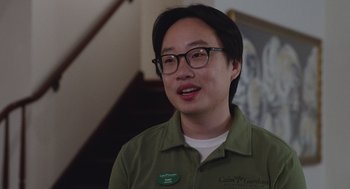Movie still from “80 for Brady” (2023), directed by Kyle Marvin – A man with glasses and a green shirt is smiling for the camera; Close Up shot, Low angle