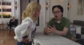 Movie still from “80 for Brady” (2023), directed by Kyle Marvin – A man and a woman looking at a phone; Medium shot, Over the shoulder angle