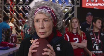 Movie still from “80 for Brady” (2023), directed by Kyle Marvin – An older woman holding an american football in her hands; Close Up shot, Over the shoulder angle