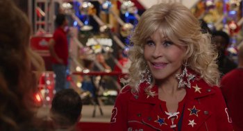 Movie still from “80 for Brady” (2023), directed by Kyle Marvin – A woman in a red jacket with stars in her hair; Close Up shot, Over the shoulder angle