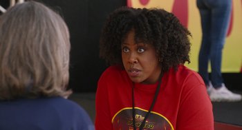 Movie still from “80 for Brady” (2023), directed by Kyle Marvin – A woman in a red shirt is sitting in front of another woman; Close Up shot, Over the shoulder angle