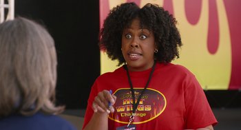 Movie still from “80 for Brady” (2023), directed by Kyle Marvin – A woman in a red t - shirt is holding a marker; Close Up shot, Over the shoulder angle