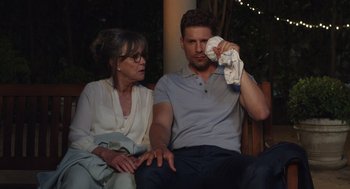 Movie still from “80 for Brady” (2023), directed by Kyle Marvin – An older woman sitting next to a young man holding a towel; Medium shot, Over the shoulder angle