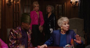 Movie still from “80 for Brady” (2023), directed by Kyle Marvin – A group of people sitting at a table with cards; Medium shot, Over the shoulder angle