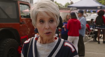 Movie still from “80 for Brady” (2023), directed by Kyle Marvin – An older woman with short blonde hair wearing a sweater; Close Up shot, Over the shoulder angle