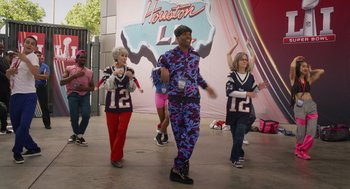 Movie still from “80 for Brady” (2023), directed by Kyle Marvin – A group of people that are standing in the street; Wide shot, High angle