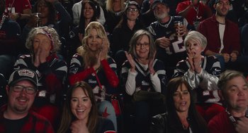 Movie still from “80 for Brady” (2023), directed by Kyle Marvin – A group of people sitting in a stadium watching a football game; Medium shot, High angle