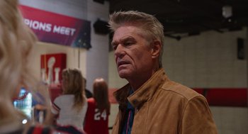 Movie still from “80 for Brady” (2023), directed by Kyle Marvin – A person wearing a brown jacket; Close Up shot, Over the shoulder angle