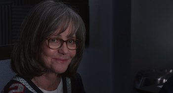 Movie still from “80 for Brady” (2023), directed by Kyle Marvin – An older woman wearing glasses and smiling for the camera; Close Up shot, Over the shoulder angle