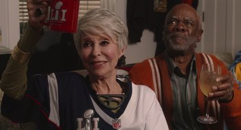 Movie still from “80 for Brady” (2023), directed by Kyle Marvin – An older woman and a younger man sitting next to each other; Medium shot, Over the shoulder angle