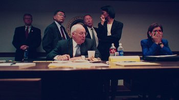 Movie still from “9/11: Inside the President's War Room” (2021), directed by Adam Wishart – A group of people sitting around a conference room table; Medium shot, High angle
