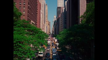Movie still from “9/11: Inside the President's War Room” (2021), directed by Adam Wishart – A city street filled with lots of traffic and tall skyscrapers; Extreme Wide shot, High angle