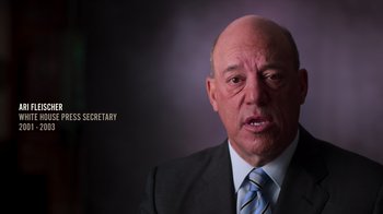 Movie still from “9/11: Inside the President's War Room” (2021), directed by Adam Wishart – An older man in a suit and tie; Close Up shot, Low angle
