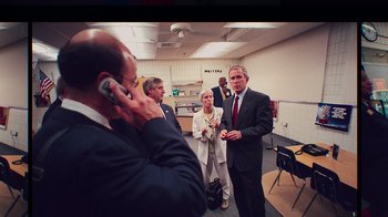 Movie still from “9/11: Inside the President's War Room” (2021), directed by Adam Wishart – A group of people standing in a room talking to each other; Medium shot, High angle