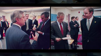 Movie still from “9/11: Inside the President's War Room” (2021), directed by Adam Wishart – Two men in suits and red ties standing next to each other; Medium shot, Over the shoulder angle