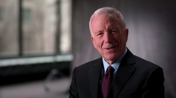 Movie still from “9/11: Inside the President's War Room” (2021), directed by Adam Wishart – An older man wearing a suit and tie; Close Up shot, Low angle