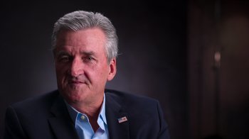 Movie still from “9/11: Inside the President's War Room” (2021), directed by Adam Wishart – An older man wearing a suit and a blue shirt; Close Up shot, Low angle