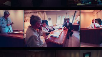 Movie still from “9/11: Inside the President's War Room” (2021), directed by Adam Wishart – Three people sitting at a table in a room; Medium shot, High angle