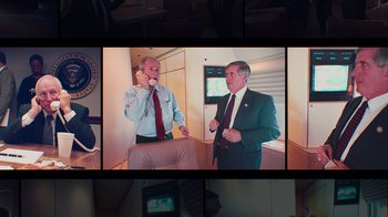 Movie still from “9/11: Inside the President's War Room” (2021), directed by Adam Wishart – Two men in suits talking on a cell phone; Medium shot, High angle