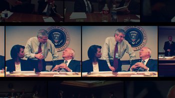 Movie still from “9/11: Inside the President's War Room” (2021), directed by Adam Wishart – Two men and a woman sitting in front of a table; Medium shot, Over the shoulder angle