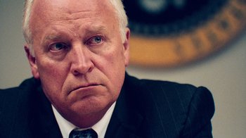 Movie still from “9/11: Inside the President's War Room” (2021), directed by Adam Wishart – An older man wearing a suit and tie; Close Up shot, Low angle