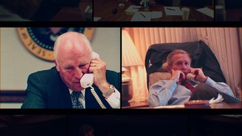 Movie still from “9/11: Inside the President's War Room” (2021), directed by Adam Wishart – A man talking on a phone while sitting in a chair; Medium shot, High angle
