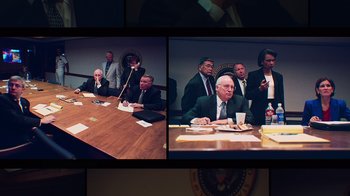 Movie still from “9/11: Inside the President's War Room” (2021), directed by Adam Wishart – A group of men sitting at a table in a room; Medium shot, High angle