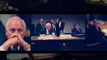 Movie still from “9/11: Inside the President's War Room” (2021), directed by Adam Wishart – A group of people sitting around a table; Medium shot, High angle