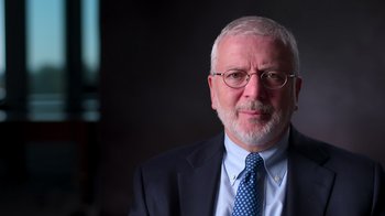 Movie still from “9/11: Inside the President's War Room” (2021), directed by Adam Wishart – An older man wearing a suit and tie; Close Up shot, Low angle