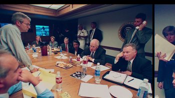 Movie still from “9/11: Inside the President's War Room” (2021), directed by Adam Wishart – A group of people sitting around a table; Medium shot, High angle