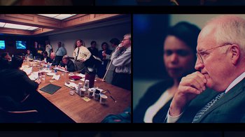Movie still from “9/11: Inside the President's War Room” (2021), directed by Adam Wishart – A group of people sitting around a table; Medium shot, Over the shoulder angle