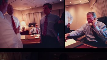 Movie still from “9/11: Inside the President's War Room” (2021), directed by Adam Wishart – A group of people in a room talking to each other; Medium shot, Over the shoulder angle